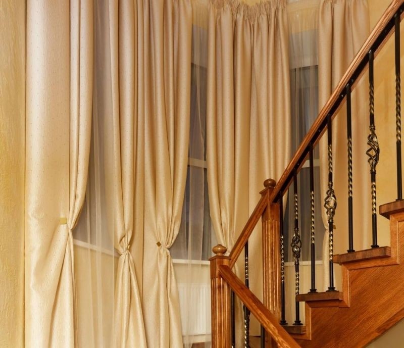 Окна на лестнице с платными шторами.